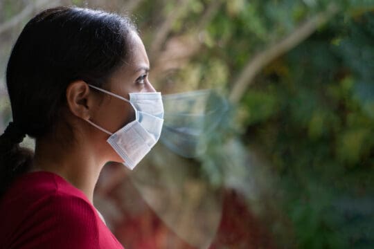 Woman wearing a face mask and looking unhappy because she wants a divorce during the coronavirus